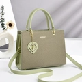 Elegante hellgrüne gewebte Handtasche mit goldenen Beschlägen und Perlenanhänger - Grün
