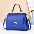 Detail van de koningsblauwe gewatteerde handtas met gouden parelgesp en stiksels - Lengte 27cm Breedte 10cm Hoogte 18cm / Blauw