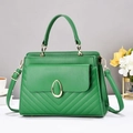 Detail of green V-quilted handbag showing gold hardware and adjustable crossbody strap - Green