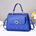 Close-up of royal blue handbag with heart quilting and golden heart twist lock - Blue