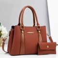 Detail der braunen Handtasche mit Wellenmuster und goldenen Metallbeschlägen - Erdgelb