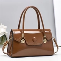 Detail of caramel brown patent leather handbag with gold fan-shaped hardware and a glossy finish - Coffee