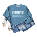 Flat lay of gray-blue Booktrovert sweatshirt with white text print and lifestyle props - S / Blue Sweatshirt (White Font)