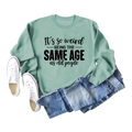 Casual light green crewneck sweatshirt featuring black 'It's so weird' text print - S / Light Green (Black Text)