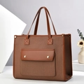 Close-up of color-block canvas tote with front pocket and gold hardware details - Earthy Yellow