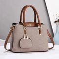 Detail of canvas tote bag with contrast faux leather trim and heart logo charm - Earthy Yellow