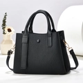 Sac à main noir avec texture tressée, poignées et bandoulière dans un décor de studio moderne - L26xl10xH19cm / Noir