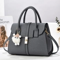 Détail du sac cabas gris tissé avec fermoir doré rotatif et pendentif d'agneau en peluche - 29x14x22 / Gris