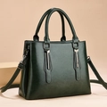 Elegante donkergroene vintage handtas met glanzende lederen textuur en zilveren details - Donkergroen