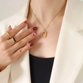 Minimalistische goldene Titanstahl-Halskette mit Lavatextur und Herzanhänger an einem Modell - Gehämmertes Rechteck (P636) / Gold