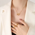 Goldenes Herz-Halsketten-Set mit gesteppten Ringen an Model im weißen Blazer - Hohlherz (P635) / Gold