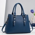 Détail du sac à main bleu marine en cuir grainé avec clous dorés et bandoulière - Bleu