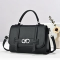 Chic black lychee grain leather handbag with silver clasp on minimalist display pedestal - Black
