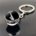 Vue macro d'un porte-clés saxophone en argent avec cabochon en verre sur surface noire - Style de Saxophone (XSWX2246-7)