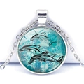 Round glass pendant necklace with black tribal dolphin art on a blue ocean background - Dolphin Pattern (XSWX3529-2) / Silver