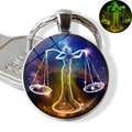 Glow-in-the-dark Libra zodiac sign pendant keychain featuring a purple starry night design - Libra