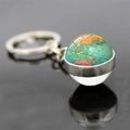 Détail macro du porte-clés globe terrestre en verre avec reflet sur miroir noir poli - Carte Détaillée Vive (JY006262-24)