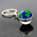 Globe and airplane keychain with a glass ball pendant reflecting on a sleek dark surface - Standard Blue Green Earth (JY006262-4)
