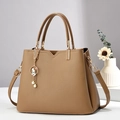 Détail du sac à main en cuir litchi marron avec pendentif lapin et pompon de perles - Kaki