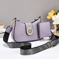 Detalle del bolso de hombro lila en piel granulada con emblema dorado y correa ancha - L25 A7 A19 / Púrpura