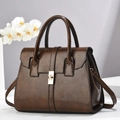 Gros plan d'un sac à main marron foncé vintage avec finition brillante et fermoir doré - Marron / 29x14x22