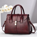 Sac à main élégant rouge foncé en cuir avec boucle dorée et doubles poignées en studio - Bordeaux / 29x14x22