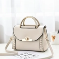 Detail of cream white leather bag with gold semi-circle handle and woven side texture - Cream White