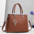 Detail of brown leather tote with stripe texture and a smiley face metal pendant - Earthy Yellow