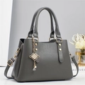 Detail of dark grey striped handbag with gold hardware and pearl Chinese knot charm - L28 W13 H20 / Gray
