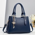 Détail du sac à main rayé bleu marine avec garniture dorée et pendentif en perles - L28 l13 H20 / Bleu