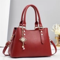 Detailed view of red pleated striped handbag with golden weave charm and pearl accents - L28 W13 H20 / Red