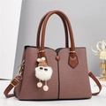 Detailansicht der rosa Stofftasche mit braunen Ledergriffen und flauschigem Anhänger - L28 B12 H20 / Braun