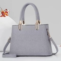 Modische gewebte Handtasche mit grau-weißem Twill-Muster und goldenen Metallelementen - Blau