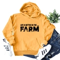 Flat lay of yellow 'Life is Better on the Farm' hoodie with tractor and wheat graphics - S / Yellow