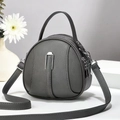 Detail van grijze ronde crossbodytas met kiezellederen textuur en dubbele ritssluiting - donkergrijs