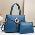 Detail view of navy blue lychee grain leather tote set with gold logo and tassel accent - 29x12x22cm / Dark Blue