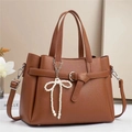Detail of brown litchi pattern leather tote bag with pearl bow charm and strap - L29 W13 H22cm / Earthy Yellow