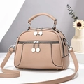 Détail du sac à main en cuir beige texture litchi avec fermetures éclair argentées - Abricot