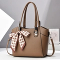 Primer plano del bolso tote marrón textura litchi con detalle de lazo de pata de gallo - Caqui