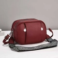 Close-up of deep red lychee grain leather crossbody bag with triple zipper compartments - 24x10x16cm / Wine Red