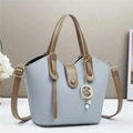 Light blue bucket bag detail showing caramel leather strap and golden moon pendant - 28x9x18cm / Blue
