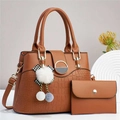 Detail of brown leather tote bag with crocodile pattern and decorative plush charm - Earthy Yellow