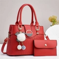 Detail of red stone texture handbag with crocodile pattern base and plush ball charm - Red