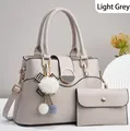 Détail d'un ensemble sac à main gris clair avec finitions dorées et nœud en peluche - Gris clair