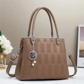 Close-up of brown textured leather bag with star charm and pearl decorations - Khaki