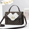 Detail of square handbag showing monogram pattern, gold logo buckle, and accordion sides - Coffee / 22x8x15cm