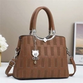 Détail d'un sac à main en cuir marron avec fermoir métallique et breloque ours - L25 l11 H19 / Marron