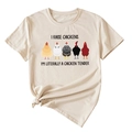 Detail of cream cotton T-shirt featuring chicken illustrations and decorative hem knot - S / Sand (Black Text)