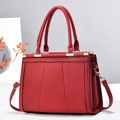 Détail du sac à main rouge matelassé avec texture litchi et finitions dorées - Bordeaux