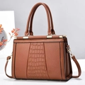 Detailed view of brown tote bag with crocodile texture panels and gold metal hardware - Medium / Earthy Yellow